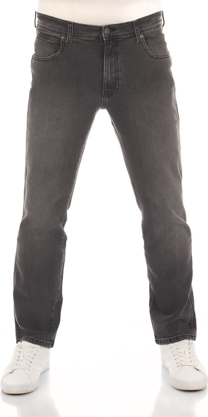Man in een grijze regular/straight fit Wrangler jeans met witte sneakers.