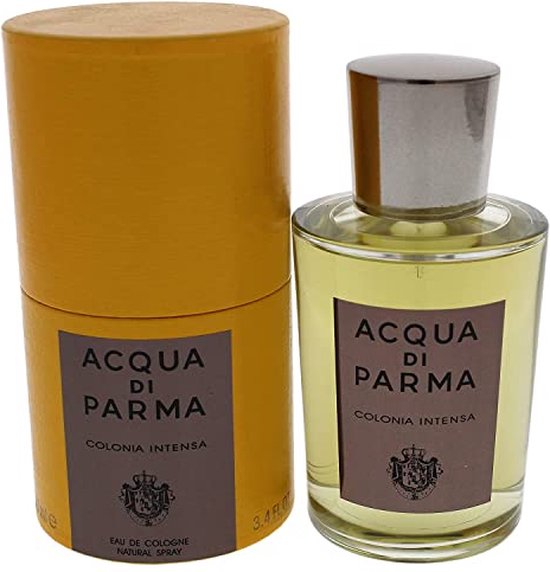 Gouden cilinder naast een glazen fles met gele vloeistof en zilveren dop. Beide met "ACQUA DI PARMA COLONIA INTENSA" erop.