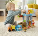 Kind gebruikt de kraan op de Fisher-Price bouwplaats-speelset om een steen te verplaatsen.