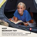 Vrouw leest een boek in een tent, met de tekst 'KEEP BEDROOM TIDY'.