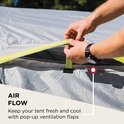 Handen sluiten de ventilatieflap van een tent, met de tekst 'AIR FLOW'.