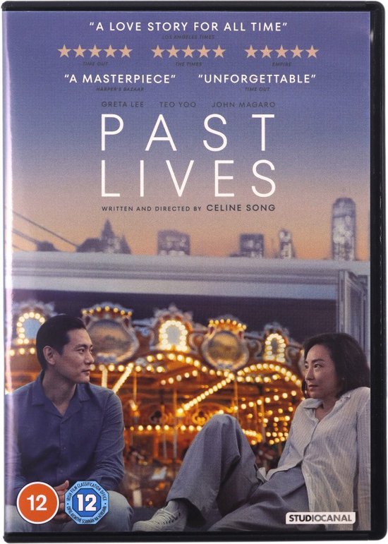 Een man en vrouw zitten tegenover elkaar met een kermis op de achtergrond, met de titel 'Past Lives'.