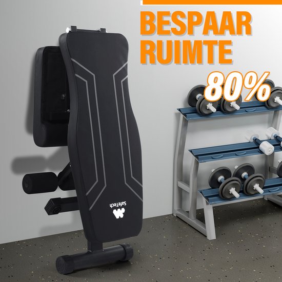 Zwarte, opgevouwen halterbank van Safetech die 80% ruimte bespaart, naast een dumbbellrek.