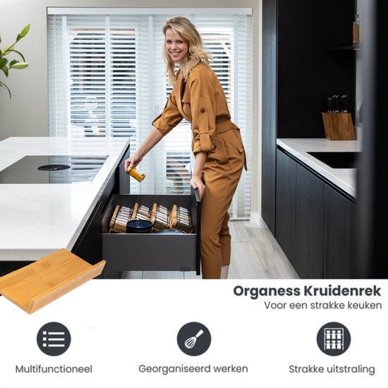 Vrouw in oranje jumpsuit in een keuken, naast een open lade met een kruidenrek en kruidenpotjes. Organess Kruidenrek.