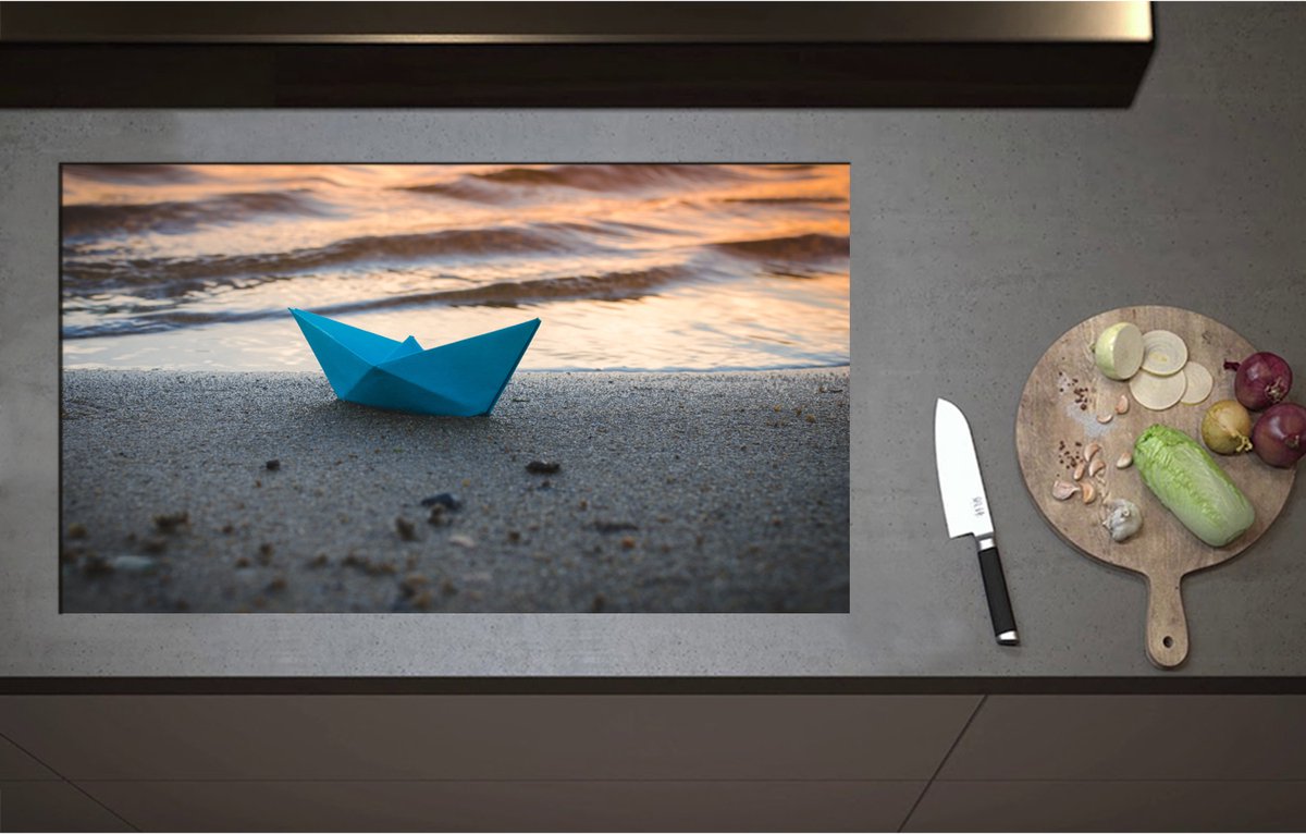Inductieplaat Beschermer - Blauwe Papieren Origami Bootje Aangespoeld op het Strand tijdens Opkomende Zon - 90x52 cm - 2 mm Dik - Inductie Beschermer - Bescherming Inductiekookplaat - Kookplaat Beschermer van Zwart Vinyl