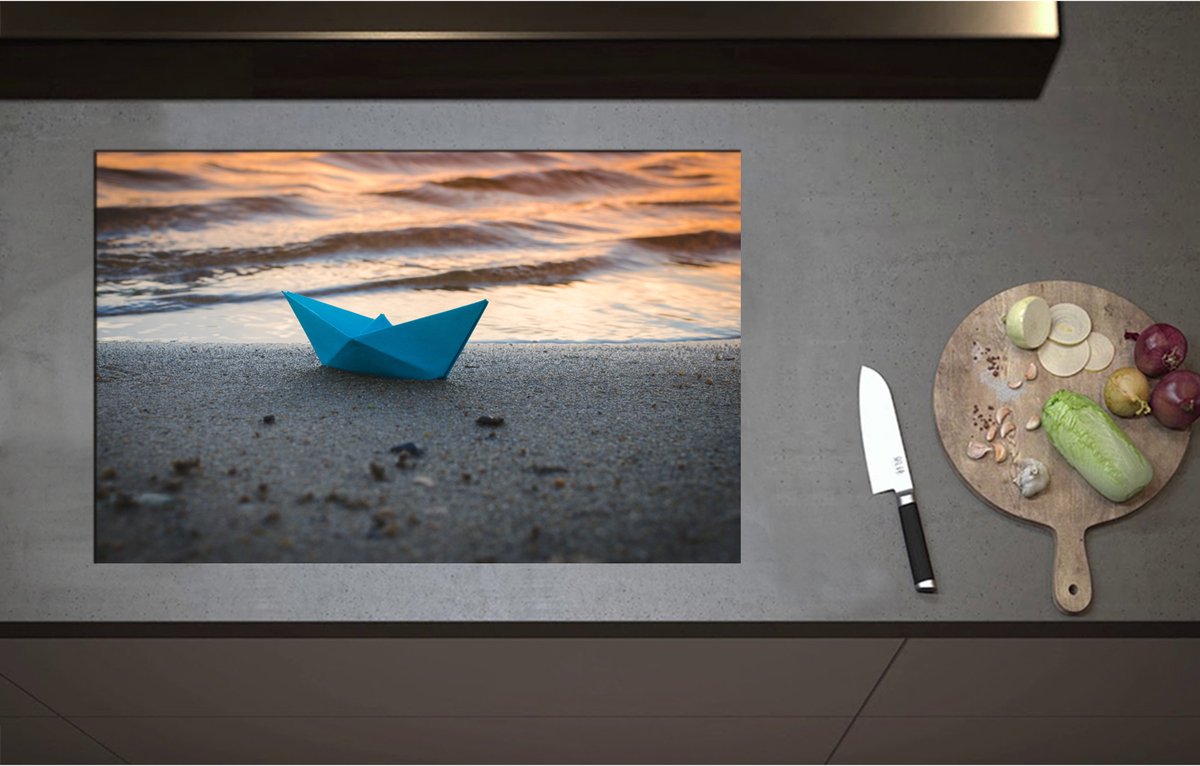 Inductieplaat Beschermer - Blauwe Papieren Origami Bootje Aangespoeld op het Strand tijdens Opkomende Zon - 80x52 cm - 2 mm Dik - Inductie Beschermer - Bescherming Inductiekookplaat - Kookplaat Beschermer van Zwart Vinyl