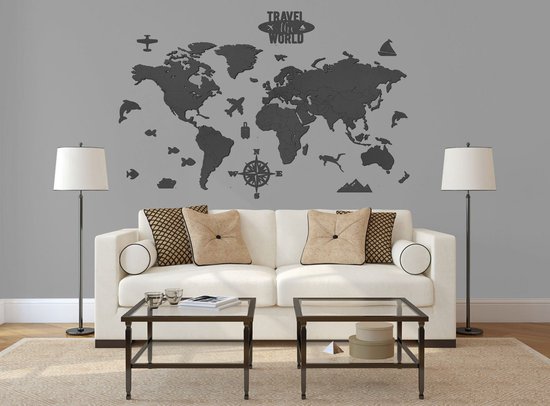 Sticker carte du monde noire avec avions, baleines et boussole, au-dessus d'un canapé blanc.