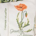 Détail d'une broderie en point de croix d'un coquelicot orange.