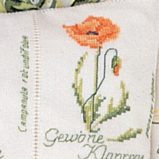 Détail d'une broderie en point de croix d'un coquelicot orange.