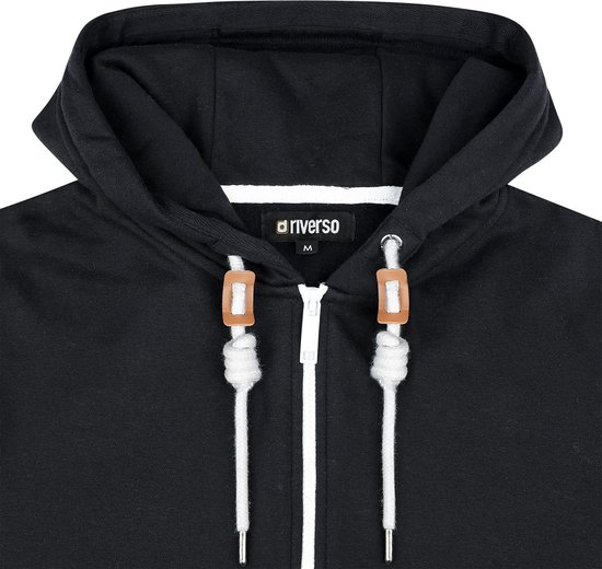 Sluiting en capuchon van een zwarte hoodie met rits en witte koordjes.