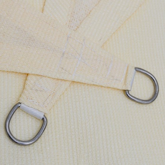 Detail van beige zonnedoek met verstevigde hoeken en metalen ringen.
