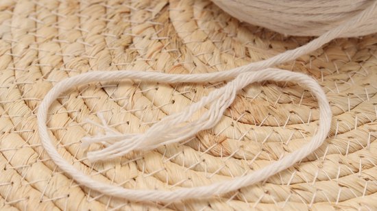 Close-up van naturel macramé koord op een rieten ondergrond.