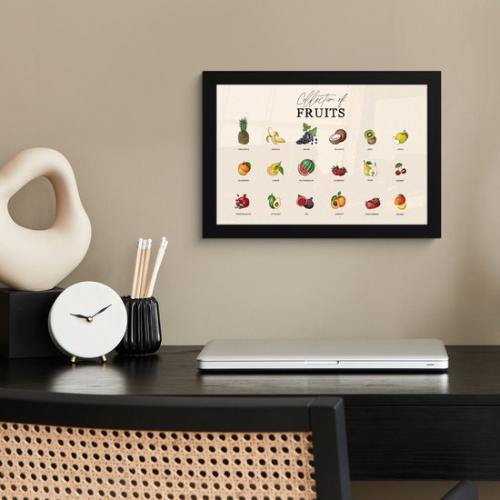Affiche noir encadré avec diverses variétés de fruits, suspendu au-dessus d'un bureau avec un ordinateur portable et une horloge.