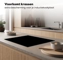 Zwarte inductiebeschermer op een kookplaat in een moderne keuken.