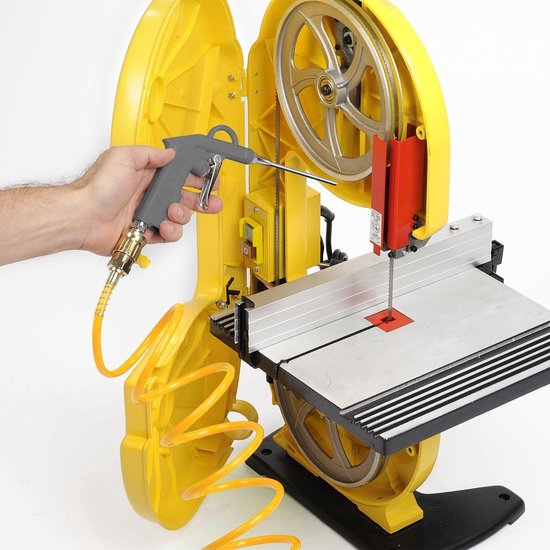 Hand met grijs blaaspistool dat op een gele lintzaagmachine wordt gericht.