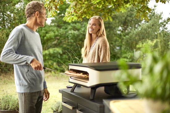 Man met bril en vrouw lachen bij een Cozze pizzamaker.