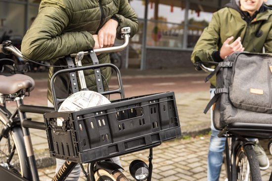 Fiets met zwarte opklapbare krat op het voordek. Twee mannen met fietsen.