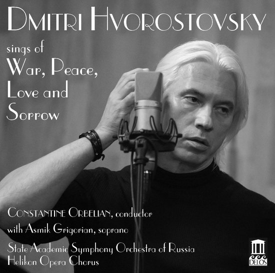 Dmitri Hvorostovsky, met lang wit haar, met de hand aan zijn hoofd, voor een microfoon. Zwart-wit opname.