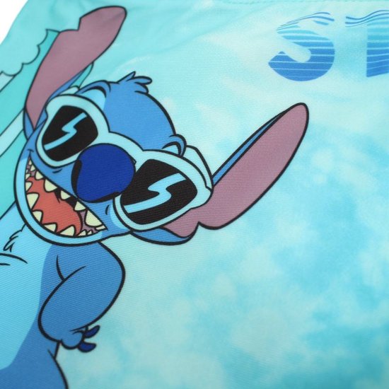 Close-up van een blauwe Stitch uit Disney, met zonnebril, die surft op een blauw tie-dye patroon.