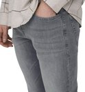 Close-up van de zijkant van een grijze jeans, met de hand in de zak.