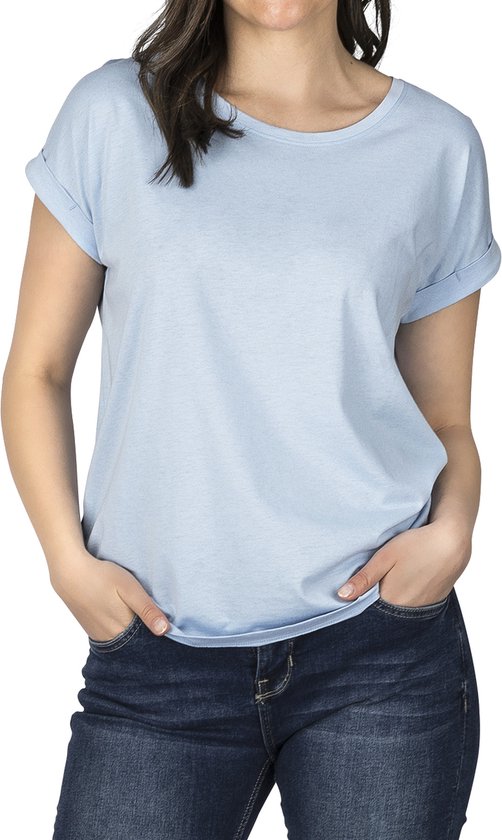 Model in een effen lichtblauwe top met korte, opgerolde mouwen.