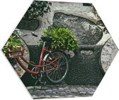 WallClassics - PVC Schuimplaat Hexagon - Rode Fiets versierd met Planten tegen Stenen Muur - 80x69.6 cm Foto op Hexagon (Met Ophangsysteem)