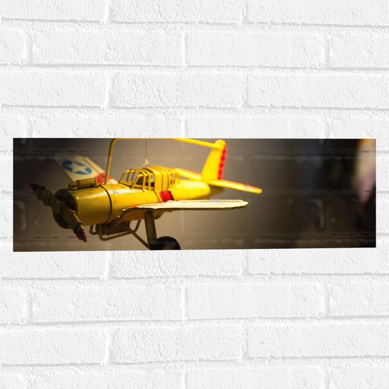 WallClassics - Muursticker - Geel Kinderspeelgoed Vliegtuigje Zwevend in Kinderkamer - 60x20 cm Foto op Muursticker