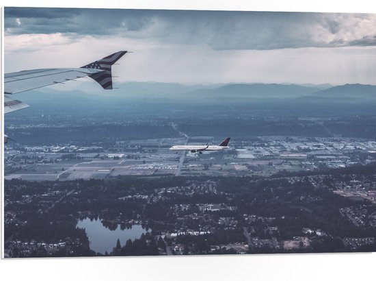 WallClassics - PVC Schuimplaat - Twee Vliegtuigen vlak boven het Land - 75x50 cm Foto op PVC Schuimplaat (Met Ophangsysteem)