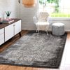 Tapis gris à motif vintage, au milieu d'un salon lumineux et décoré de manière moderne.