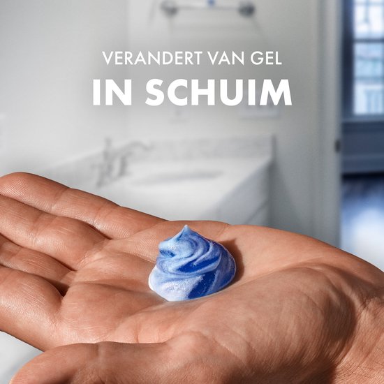 Hand houdt een toefje blauw-wit scheerschuim vast. "Verandert van gel in schuim".