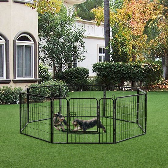 Twee honden spelen in een zwarte, achthoekige metalen puppyren in een tuin.