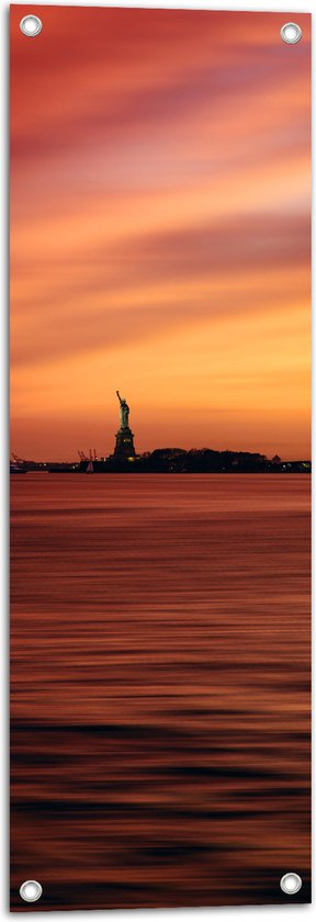 WallClassics - Tuinposter – Vrijheidsbeeld in New York van Ver met Zonsondergang - 30x90 cm Foto op Tuinposter (wanddecoratie voor buiten en binnen)