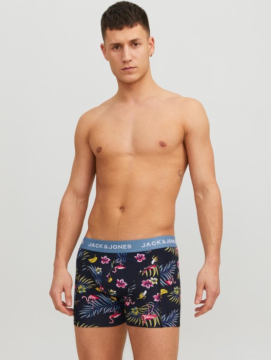 Man met donkerblauwe boxershorts met tropische print van flamingo's, bloemen en bladeren. Blauwe JACK & JONES tailleband.