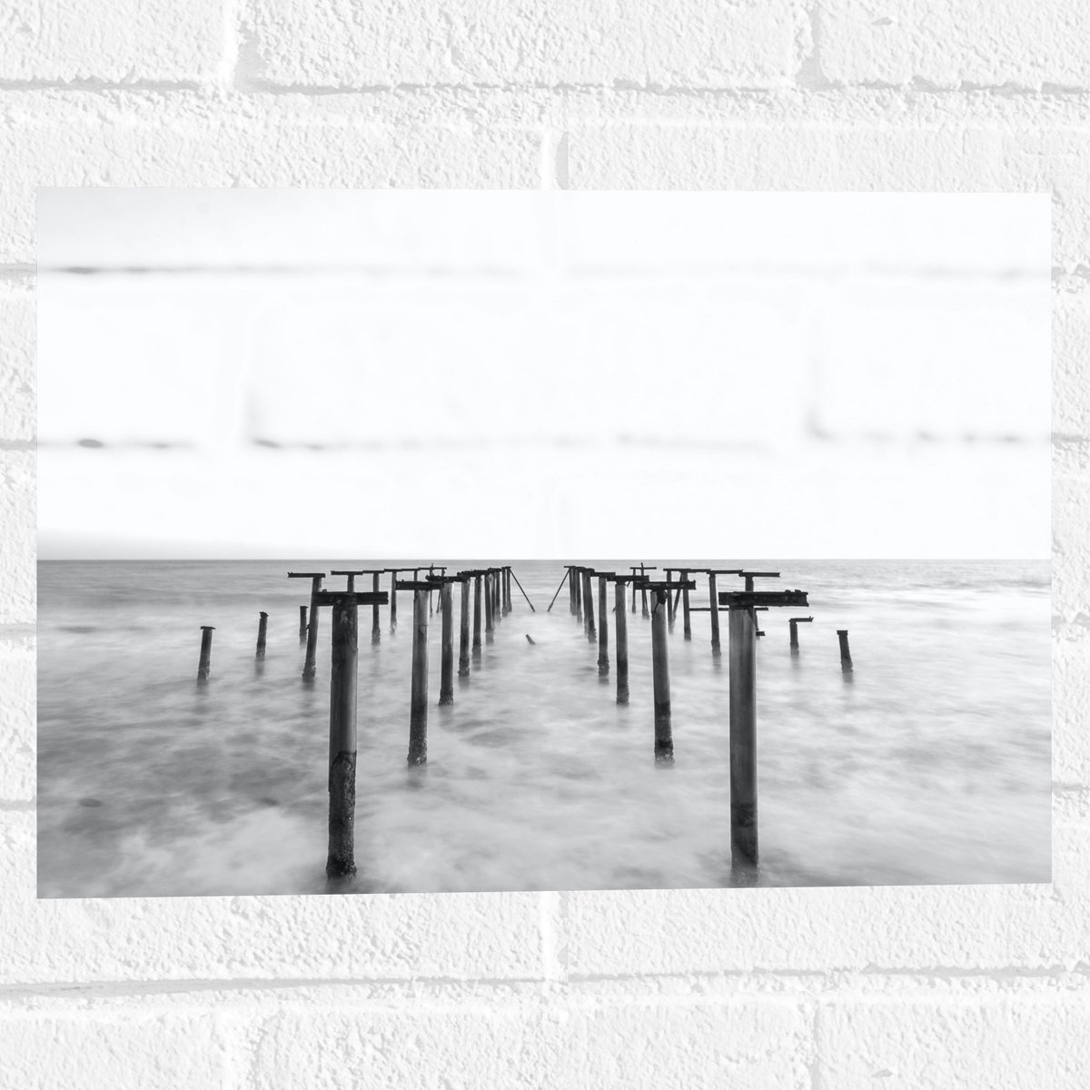 Muursticker - Rij Palen in de Zee - 40x30 cm Foto op Muursticker