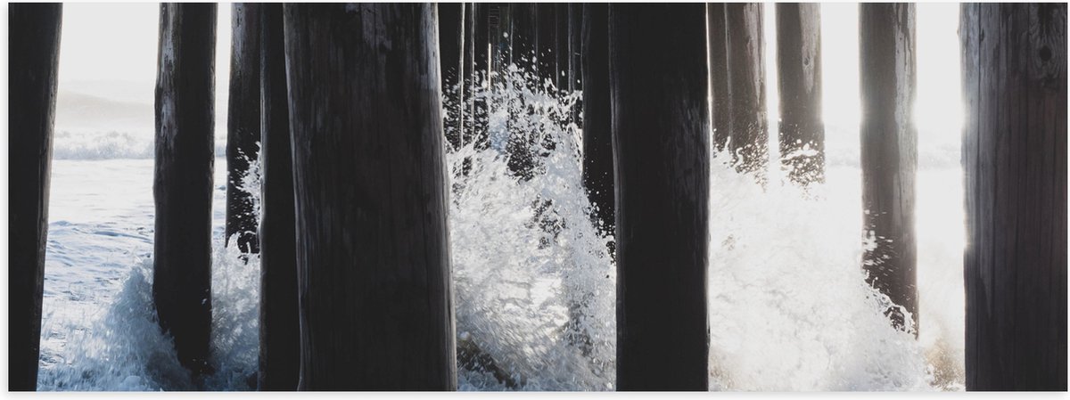 Poster (Mat) - Water klots4end tegen Houten Palen in de Zee - 90x30 cm Foto op Posterpapie