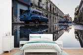 Behang - Fotobehang Vintage auto's weerspiegeld in plassen op in een straat Cuba - Breedte 390 cm x hoogte 260 cm