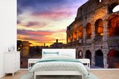 Behang - Fotobehang Het Colosseum in Rome bij een zonsondergang - Breedte 450 cm x hoogte 300 cm