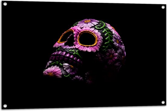Tuinposter – Doodskop Versierd met Paarse Bloemen en Groene Planten tegen Zwarte Achtergrond - 105x70 cm Foto op Tuinposter (wanddecoratie voor buiten en binnen)
