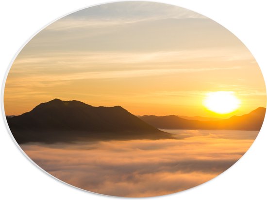 PVC Schuimplaat Ovaal - Verdwijnende Zon achter Bergen boven Wolken - 40x30 cm Foto op Ovaal (Met Ophangsysteem)