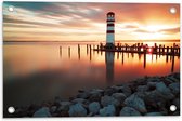 Tuinposter – Rood met Witte Vuurtoren in het Water bij Zonsondergang - 60x40 cm Foto op Tuinposter (wanddecoratie voor buiten en binnen)