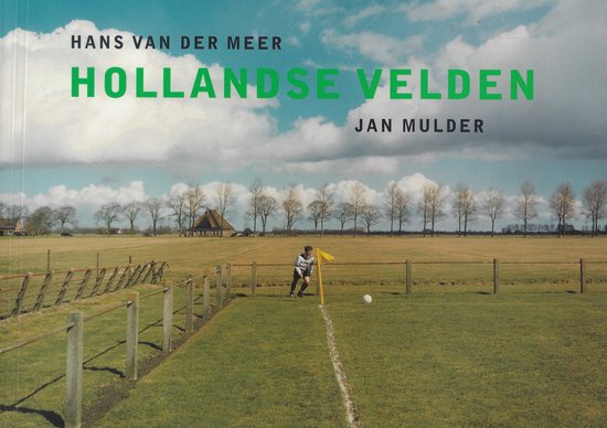 Een man in een gestreept shirt staat op een voetbalveld bij een gele vlag. Hollandse Velden is geschreven door Hans van der Meer en Jan Mulder.