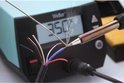 Een Weller soldeerbout met 350°C display smelt tin op een veelkleurige draadbundel.