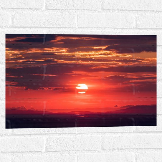 WallClassics - Muursticker - Ondergaande Zon achter Wolken - 60x40 cm Foto op Muursticker