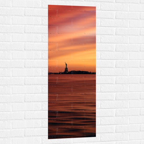 WallClassics - Muursticker - Oranje Lucht boven Vrijheidsbeeld in New York - 40x120 cm Foto op Muursticker