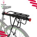 Zwarte fietsbagagedrager op een fiets met groene velgrand.