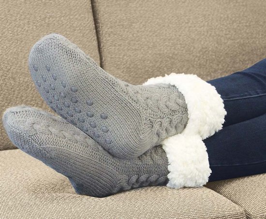 Grijze, dikke huissokken met witte fleecevoering en anti-slip noppen op de onderkant.