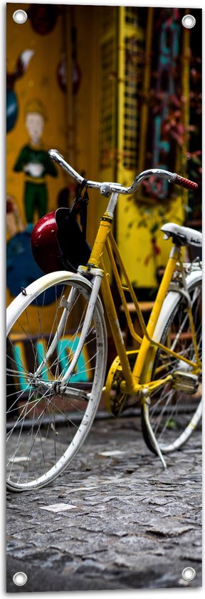 WallClassics - Tuinposter – Gele Fiets bij Geel Gebouw in de Stad - 30x90 cm Foto op Tuinposter  (wanddecoratie voor buiten en binnen)