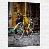 WallClassics - Muursticker - Gele Fiets bij Geel Gebouw in de Stad - 80x120 cm Foto op Muursticker