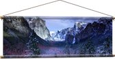 WallClassics - Textielposter - Besneeuwde Bergen met Bomen en Rotsen - 120x40 cm Foto op Textiel