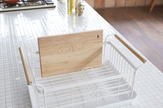 Egouttoir blanc à poignées en bois, avec une planche à découper en bois.